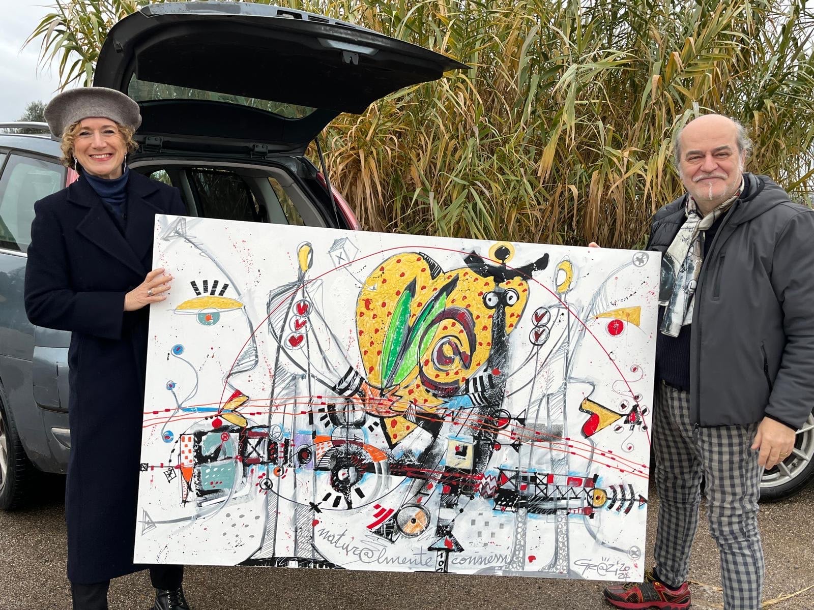 Alessandro Grazi and Silvana Muscella holding the painting